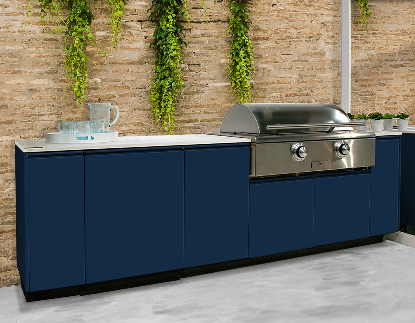 Navy outdoor cabinets with a stainless grill against a brick wall