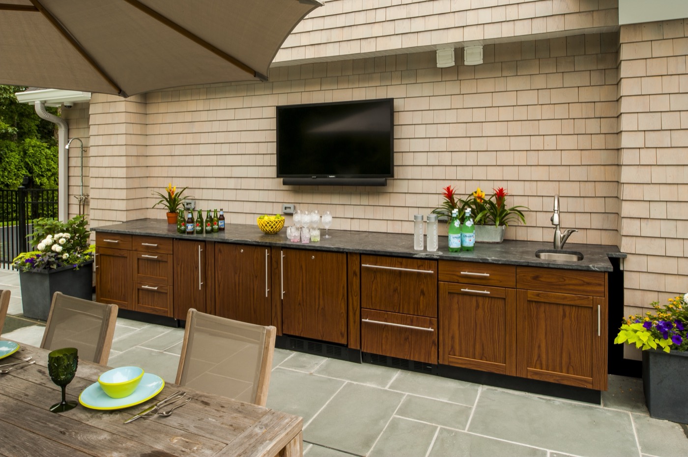 Wood-grain outdoor cabinets on a stone patio