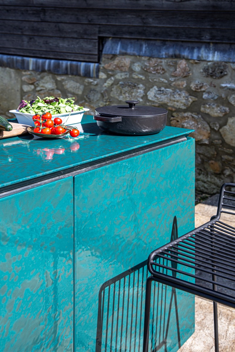 Teal porcelain enamel countertop with fresh tomatoes and a cast-iron pot